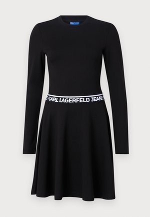 Black long-sleeve dress made of stretch fabric, featuring a fitted bodice, flared skirt, and a white branded elastic waistband.