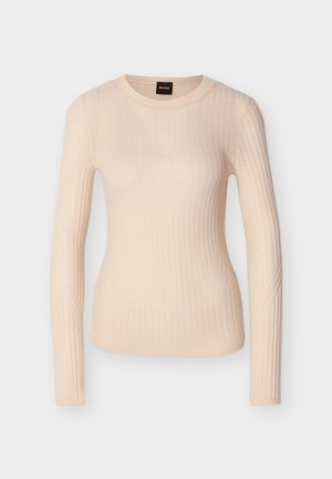 Beige ribstrikket striktrøje med lange ærmer, rund hals og tætsiddende silhuet, mærket med en sort og orange "BOSS"-mærkat ved halsudskæringen.