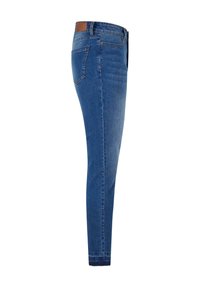 Jeans ajustados de denim azul medio, con un diseño limpio, bolsillo trasero y un parche de cuero en la cinturilla. Textura suave y corte entallado.