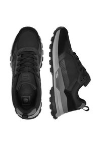 Melni sporta apavi ar fakturētu sieta virsmu, zamšādas akcentiem, polsterētu mēli un izturīgu gumijas zoli ar dziļiem protektoriem.