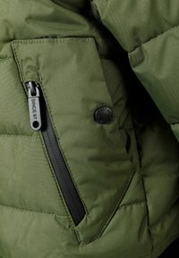 Veste matelassée verte avec une poche zippée et un rabat à boutons, fabriquée avec un tissu lisse et texturé, ainsi que des détails de couture.