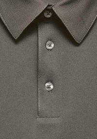 Polo gri dintr-un material texturat, cu guler clasic și trei butoane gri. Are un aspect curat și nu prezintă modele vizibile.