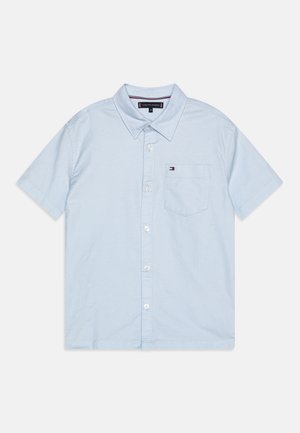 Jasnoniebieska koszula z krótkim rękawem zapinana na guziki, z kieszenią na piersi ozdobioną małym logo flagi Tommy Hilfiger.