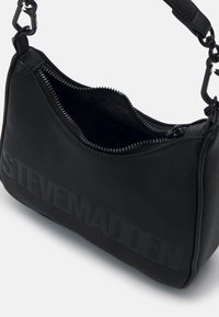 Sac bandoulière en cuir noir avec fermeture éclair argentée partiellement ouverte, logo « Steve Madden » embossé sur le devant et bandoulière réglable avec crochets clips.