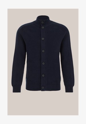 Tumesinine kardigan, mis on valmistatud soonikkoes kangast. Omadusteks on kõrge krae ja seitse eesmist nööpi, tavapärase lõikega ja kaks küljetaskut.