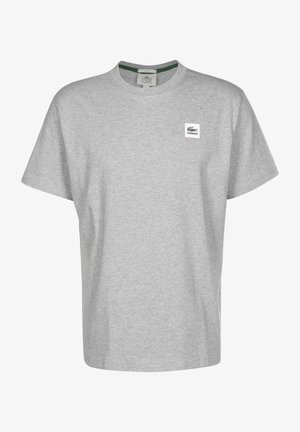 Hellgraues T-Shirt mit kurzen Ärmeln und Rundhalsausschnitt, mit kleinem Lacoste-Logo auf der linken Brust und grünem inneren Kragen.