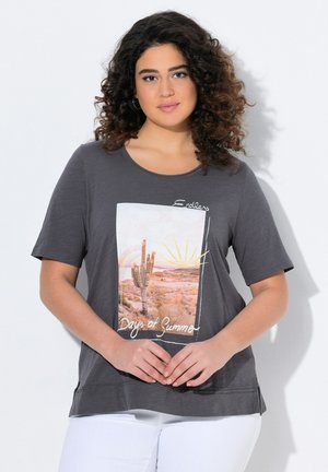 T-shirt gris foncé à manches courtes, avec un graphique coloré de désert et le texte "Jours d'Été sans Fin" en blanc. Tissu doux.