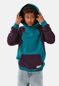 Tepid och lila huva tröja med framficka, ribbade ärmar och kontrasterande tygpaneler på sidorna; mjuk textur.