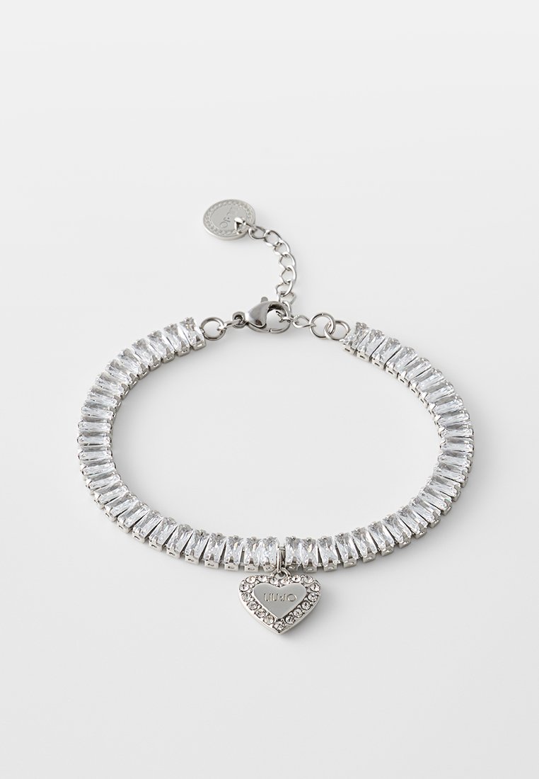 Silberfarbener Armband mit rechteckigen, klaren Kristallen, einem herzförmigen Anhänger mit der Gravur "LIU•JO", umgeben von kleinen Kristallen, und einem Karabinerverschluss.