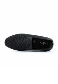 Scarpa nera slip-on con tomaia testurizzata caratterizzata da motivi simili a mesh e accenti di scintillio sottili. Fodera interna morbida con misura 3½ visibile.