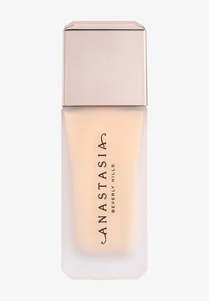 Foundation-Flasche mit mattiertem Glas-Körper und roségoldenem Deckel, beschriftet mit „Anastasia Beverly Hills“ in schwarzem vertikalem Text.