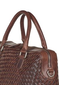 Brown woven leather bag featuring double handles, a zippered closure, metal hardware, and a textured surface with a rich pattern.