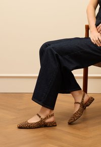 Schwarz-weiße Tiere oder Kunstleder, die geruchlos sind, und eine strukturierte Oberfläche aufweisen. Sie sind leicht und bieten gleichmäßige Unterstützung für den Fuß. Sie bieten selbst bei längerem Tragen einen hohen Komfort.