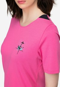 Roze katoenen t-shirt met een ronde hals en korte mouwen. Heeft een grafisch ontwerp met een anker en de tekst "LA RAISON."