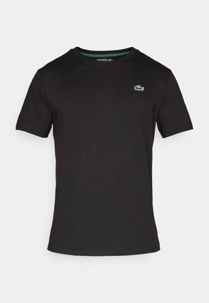 Black cotton t-shirt with a crew neckline, short sleeves, and a small green crocodile logo on the left chest. Simple, solid design.