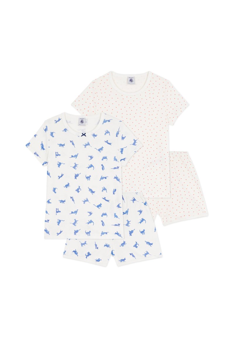Σετ αποτελούμενο από τέσσερα βαμβακερά είδη νυχτικιάς: δύο μπλουζάκια με κοντά μανίκια και μπλε σχέδια γάτας και δύο σορτς με κόκκινα πουά σε λευκό φόντο.
