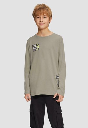 Langaarmige, licht olijfgroene katoenen t-shirt met een vierkant grafisch ontwerp op de borst en een extra label nabij de zoom.