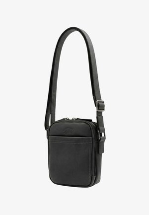 Petit sac bandoulière en cuir noir compact avec sangle réglable, poche avant et fermeture éclair double.