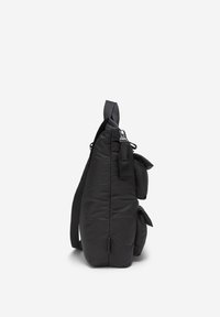 Sort puffy skuldertaske med rektangulær form, justerbar rem og to udvendige sidelommer, der har en glat overflade og lynlåsdetaljer.