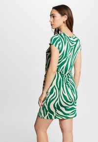 Groen en crèmekleurig gestreepte jurk met een relaxte pasvorm, korte mouwen, geplooide details op de taille en zachte, rekbare stof.
