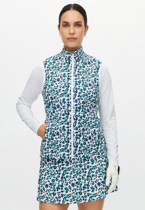 Gilet vivace senza maniche con stampa leopardata blu, verde e nero, caratterizzato da un colletto alto e una cerniera frontale. Abbinato a una gonna coordinata con lo stesso motivo.