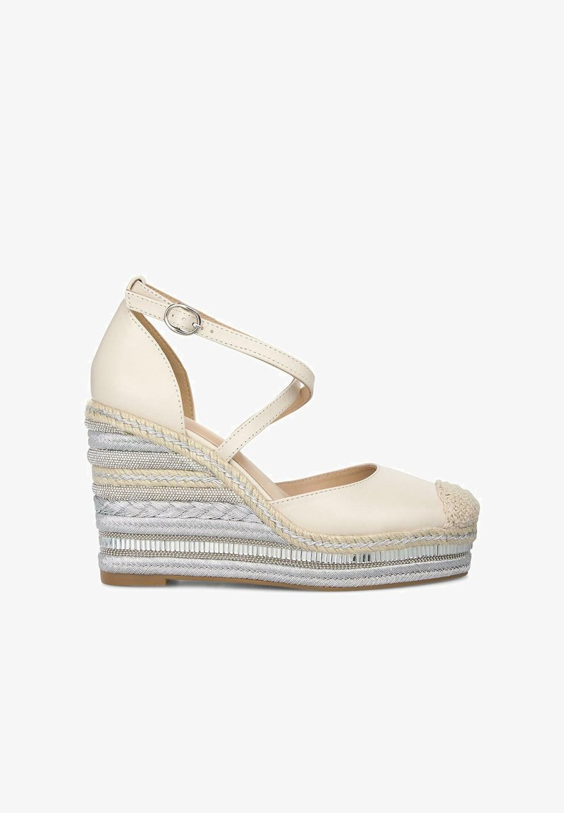Keilabsätze mit einem Obermaterial aus creamfarbenem Leder und einer geflochtenen Jute-Plattform. Verfügt über überkreuzte Knöchelriemen und eine strukturierte Zehenkappe.