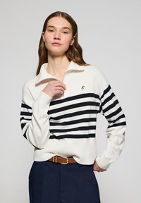 White and navy striped pullover with a half-zip collar and embroidered logo, made from a soft fabric. Features ribbed cuffs and waist.