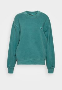 Sudadera color azul verdoso hecha de algodón, con cuello redondo acanalado, mangas largas y un pequeño parche con logotipo en el pecho izquierdo. Textura suave.