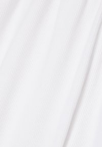 Witte stof met fijne verticale geribbelde textuur en zachte plooien.