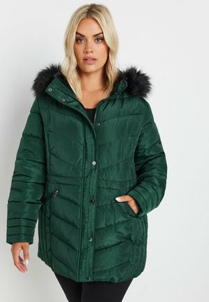 Grøn polstret jakke med hætte pyntet med pels, der har lynlåslommer i siderne, tryknapper og et struktureret quiltet design.