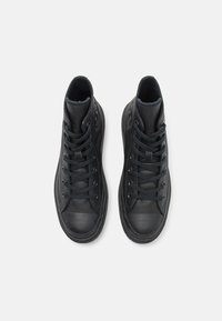 Černé vysoké tenisky s koženým svrškem, texturovanými tkaničkami, gumovou špičkou a hladkým povrchem s vyztuženým švem.