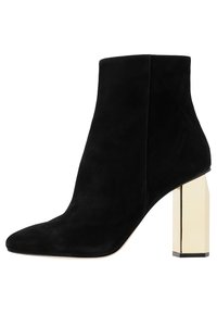 Botín de ante negro hasta el tobillo con punta afilada y tacón bloque dorado metálico. Textura suave con un detalle de costura mínimo.