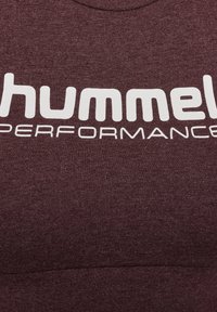 Bordeauxfarbenes Sportoberteil mit rundem Halsausschnitt. Weißes "hummel PERFORMANCE"-Logo deutlich auf der Vorderseite in fetten Großbuchstaben angezeigt.