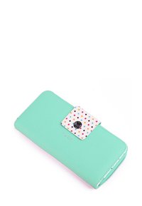 Mint green wallet with polka dot accent flap, featuring a silver snap closure and embossed brand logo. Smooth texture and rectangular shape.