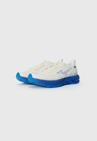 Chaussures de course légères avec une tige crème, des accents bleus et une semelle texturée. Présentent une semelle rembourrée et un design perforé pour la respirabilité.