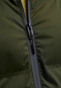 Oliwkowa kurtka puchowa z czarnym zamkiem, charakteryzująca się gładką fakturą i wewnętrzną podszewką w kontrastowym kolorze.