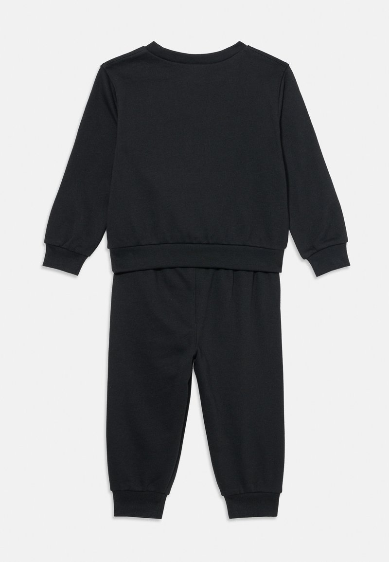 Sweatshirt noir à manches longues avec col rond et poignets côtelés, associé à un pantalon assorti avec taille élastique et jambes fuselées.