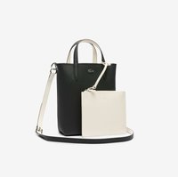Sac fourre-tout en cuir noir avec poignées supérieures et pochette blanche amovible, présentant une texture lisse et un discret logo. Bandoulière réglable.