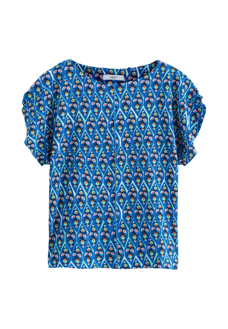 Blouse bleue à manches courtes ornée d'un motif géométrique avec des accents rouges, verts et jaunes. Fabriquée en tissu léger avec une coupe décontractée.