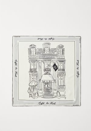 Dessin au trait noir d’un bâtiment de café avec auvent, table extérieure avec parasol, personne assise, et texte "Café de Kol" sur un tissu blanc carré.
