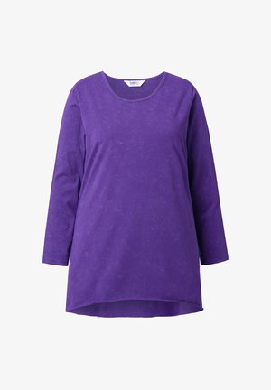 Fioletowa tunika z długim rękawem, okrągłym dekoltem i lekko dłuższym tylnym brzegiem, przedstawiona na jednolitym białym tle.