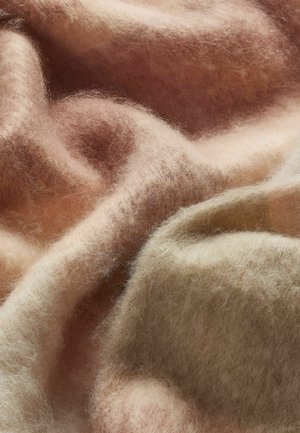 Weiche, leichte Wolldecke in Pastellfarben von Rosa und Beige, mit einer glatten Textur, natürlichen Variationen und subtilen Faserflusen.