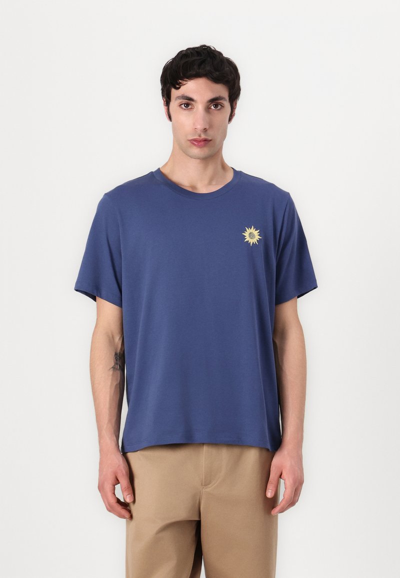 Navy blue cotton t-shirt with short sleeves and a round neckline. Features a small, yellow sun graphic on the left chest.