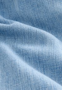 Vaaleansininen farkkukangas, sileällä pinnalla, näkyvällä vinokudoksella ja hieman kuluneella ilmeellä. Pehmeä ja taipuisa, sopii vaatteisiin.