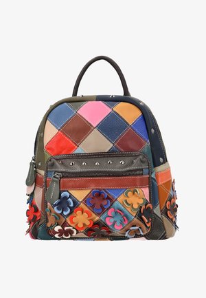 Kleine leren rugzak met meerkleurige patchwork vierkanten, voorvak met rits, bloemenapplicaties en studs details op een witte achtergrond.