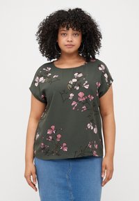 Short-sleeve dark green top featuring pink floral pattern and rounded neckline. Fabric appears smooth with a relaxed fit.