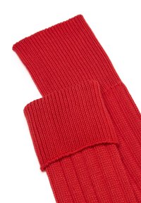 Calze rosse lavorate a maglia caratterizzate da una trama a costine, un polsino spesso e un corpo morbido. Il tessuto è soffice e presenta un motivo uniforme in tutta la superficie.