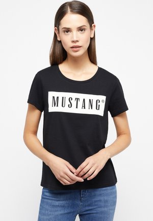 Schwarzes T-Shirt mit kurzen Ärmeln, Rundhalsausschnitt und einer weißen rechteckigen Grafik, auf der das Wort "MUSTANG" in fetten schwarzen Buchstaben dargestellt ist.