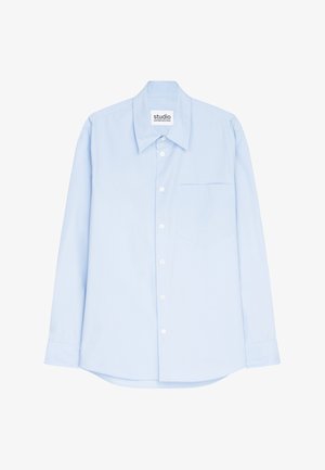 Chemise à manches longues bleu clair en tissu lisse, dotée d'un col boutonné, d'une poche avant et d'une base droite.