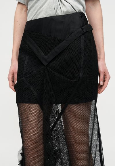 Μαύρο δίχτυ φούστα με δομημένο στρωματοποιημένο σχέδιο, ομαλή μέση και γεωμετρικές οπές. Ημιδιαφανής με υφή τελείωμα.